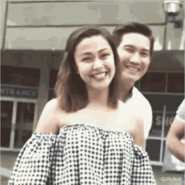 a man and a woman are posing for a picture and smiling .