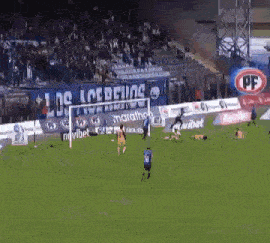 a soccer game is being played on a field with a banner that says los loberos