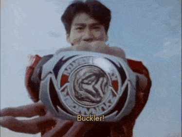 a man in a red shirt is holding a buckler in his hands .