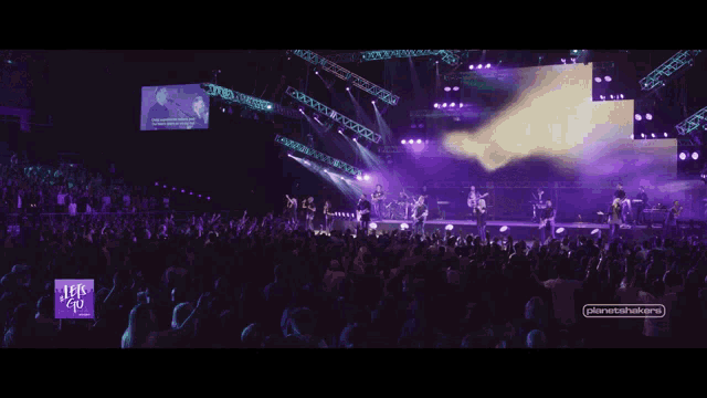 a woman singing on a stage with the words let 's go on the bottom right