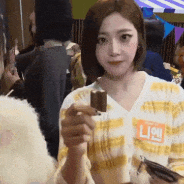 a woman in a plaid shirt is holding a small ice cream bar in her hand .