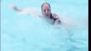 a woman in a pink bikini is swimming in a swimming pool and smiling .