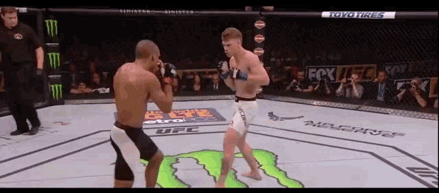 two men are fighting in a boxing ring sponsored by toyo tires and monster