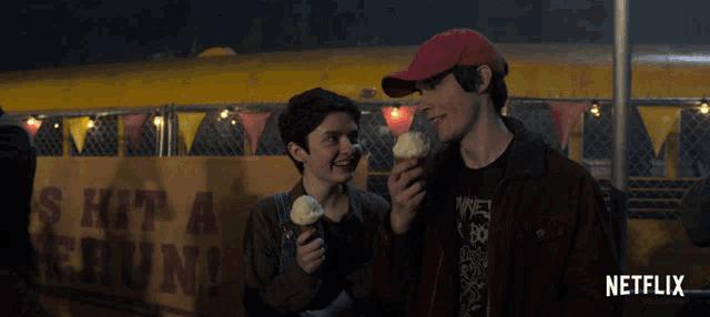 two people eating ice cream in front of a sign that says " hit a chunk "