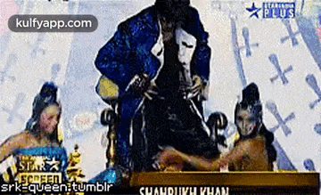 a man in a mask is sitting on a throne next to a woman in a mask .