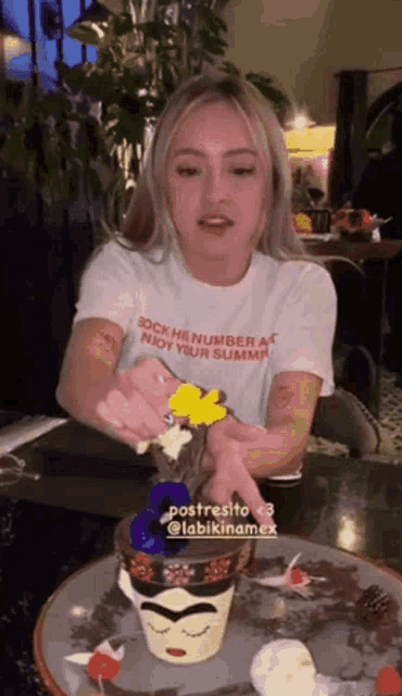 a woman sitting at a table with a t-shirt that says " enjoy your summer " on it