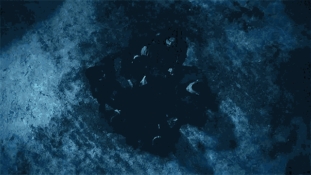 a group of people are sitting in a circle in the middle of a body of water .