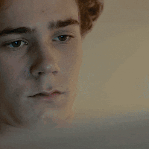 a close up of a young man 's face looking down