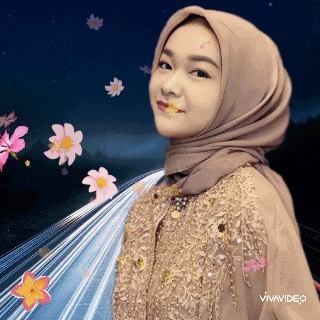 a woman wearing a hijab is standing in front of a road with flowers in the background