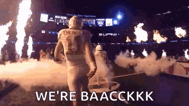 a football player with the number 11 on his jersey is walking out of the stadium .