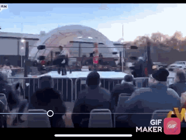 a group of people watching a wrestling match on a screen that says gif maker on it