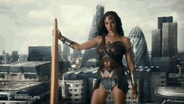 wonder woman is standing in front of a city skyline