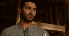 a man with a beard is holding a lighter in his hand and looking at the camera .