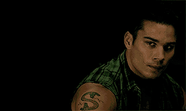 a man with a snake tattoo on his shoulder