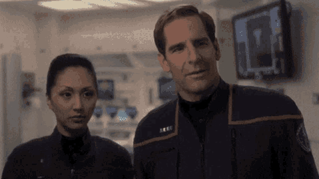 a man and a woman are standing next to each other and the man 's uniform has the word ice on it