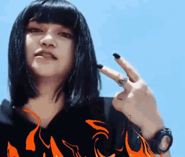 a woman with black nails is wearing a black shirt with flames on it