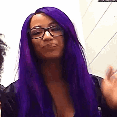 a woman with long purple hair and glasses is making a face .
