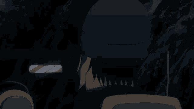 a man wearing a mask is sitting in a dark room