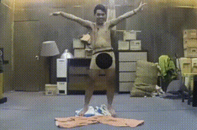 a man without a shirt is standing on a pile of clothes in a room