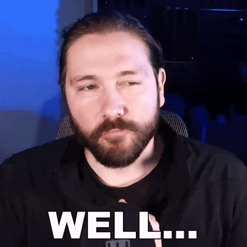 a man with a beard says well in front of a blue background