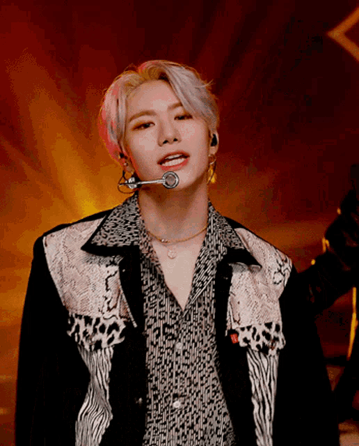 a young man wearing a leopard print shirt and a microphone