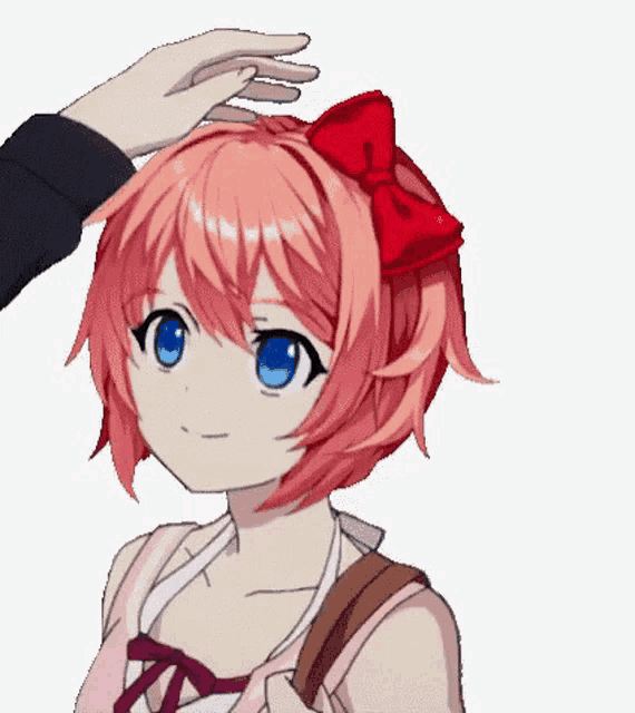 a person is touching the head of a girl with a red bow in her hair .