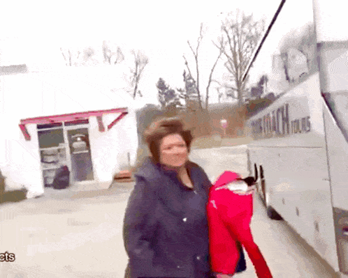 a woman is standing in front of a bus that says rick coach tours