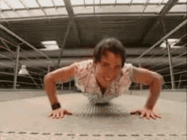 a woman is doing push ups on the floor in a boxing ring .