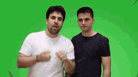 two men are standing next to each other on a green screen and making funny faces .