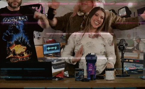 a group of people are standing around a table in front of a microphone .