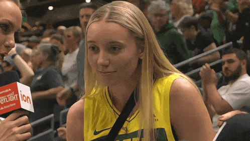 a woman is being interviewed by a reporter with a microphone that says spotlight on