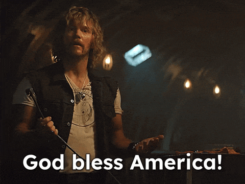 a man holding a microphone with the words god bless america on the bottom