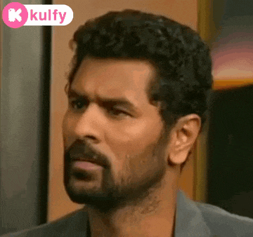 a man with a beard is making a funny face while looking at the camera .
