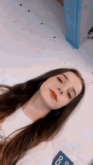 a young woman with long hair is taking a selfie with a sign in the background that says do