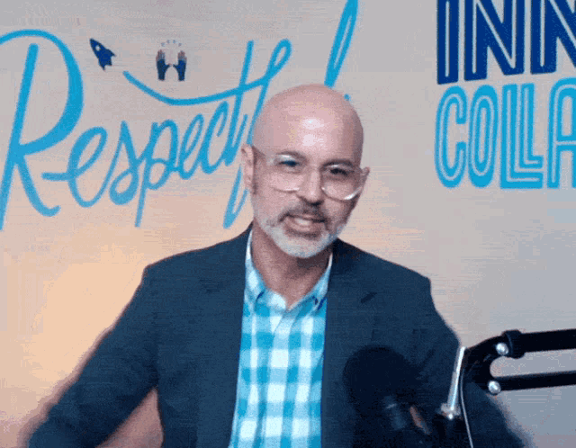 a bald man stands in front of a sign that says respect