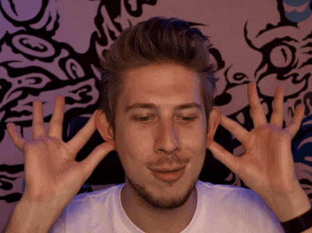 a man with a beard is making a face with his hands