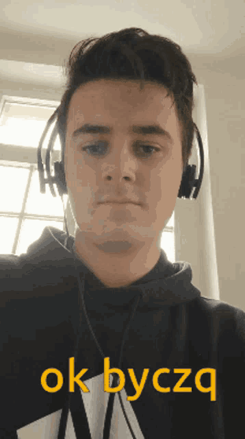 a young man wearing headphones says ok byczq in yellow letters