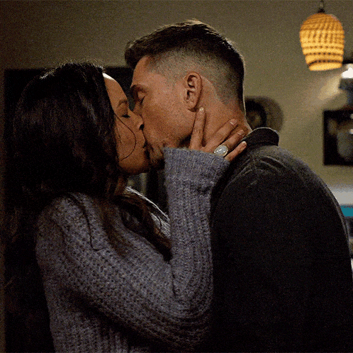 a man and a woman are kissing and the woman is wearing a ring