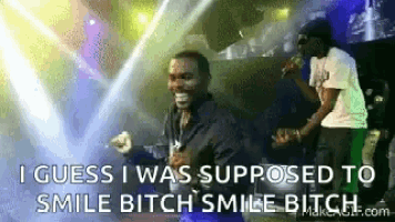 a man singing into a microphone with the words i guess i was supposed to smile bitch smile bitch .
