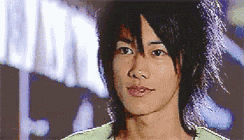 a close up of a young man 's face with long hair