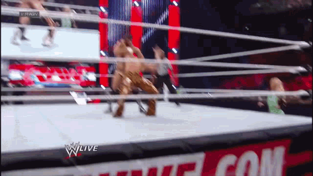 wrestlers in a wrestling ring with a sign that says wwe live