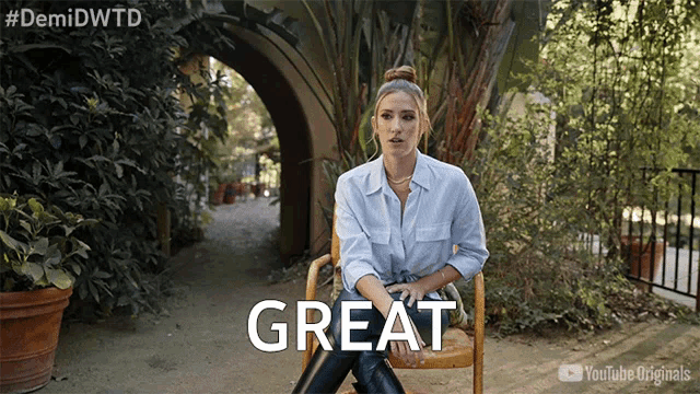 a woman sits in a chair with the word great written on the screen