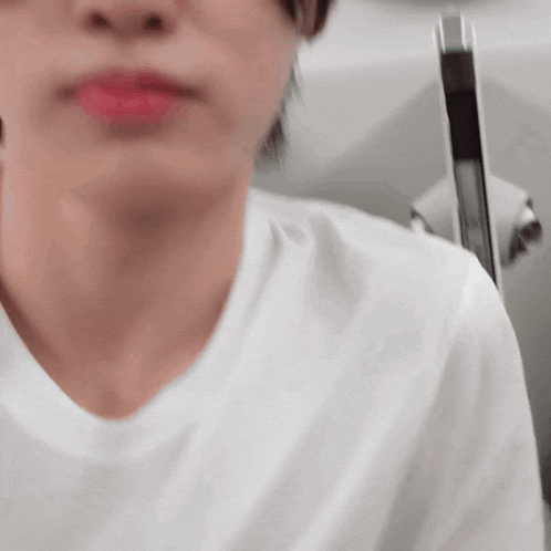 a close up of a person 's face with a white shirt on .