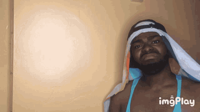 a man with a scarf around his head and the word imgplay on the bottom right