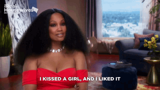 a woman in a red dress says " i kissed a girl " and " i liked it "