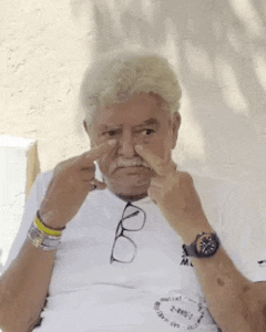 an older man wearing glasses and a watch holds his nose