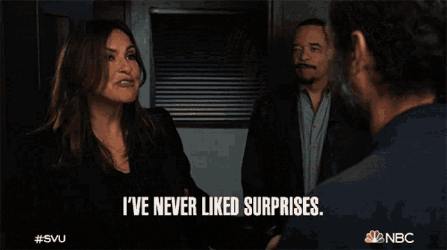 a woman says " i 've never liked surprises " in front of a group of men