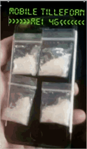 a person holding a cell phone with bags of cocaine on it