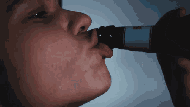 a close up of a person drinking from a bottle with a label that says ' bmw ' on it