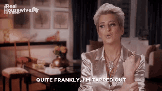 a woman says " quite frankly i 'm tapped out " in front of a sign that says real housewives